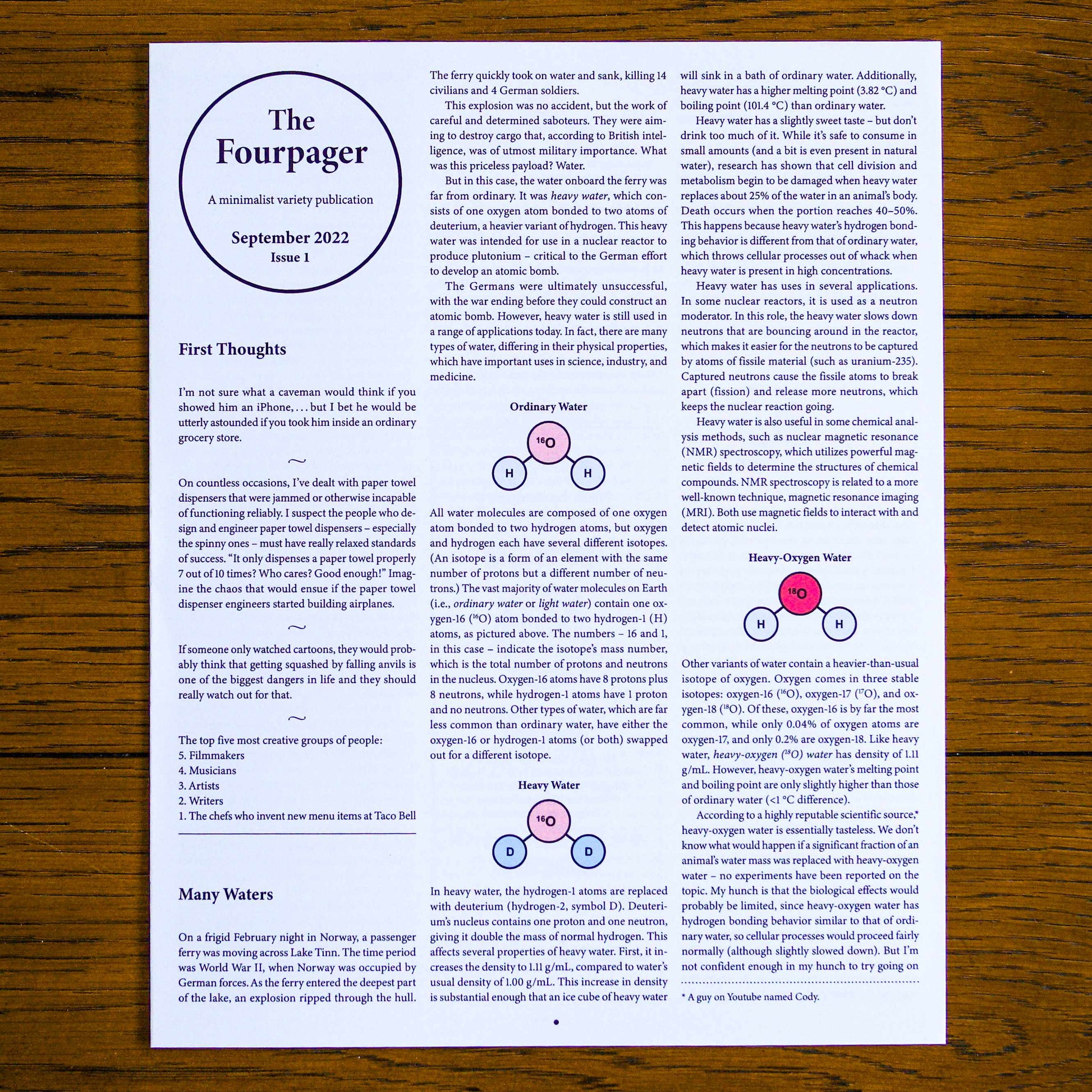 Paper publication titled 'The Fourpager' on a wooden background. Below the title reads, 'A minimalist variety publication', 'September 2022', and 'Issue 1'.